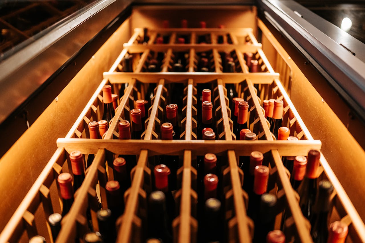 A warm-toned close-up of bottled wine stored in a wooden rack, perfect for a winery or wine cellar concept.