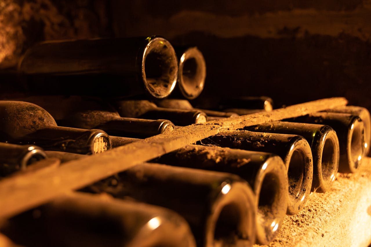 Dusty wine bottles aging in a Bordeaux cellar, showcasing vintage ambiance.